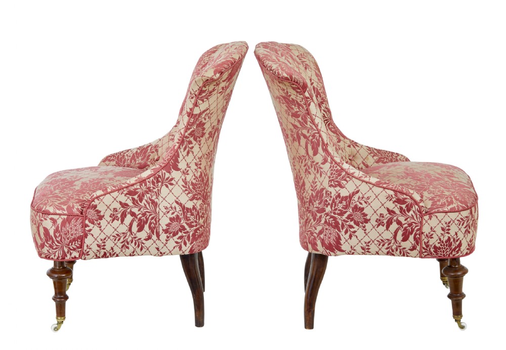 An early 20th century three-piece upholstered salon suite featuring a two-seater settee and two matching armchairs with pink and cream floral damask pattern, button-tufted fluted backs, and turned wooden legs with brass castors. View XIII