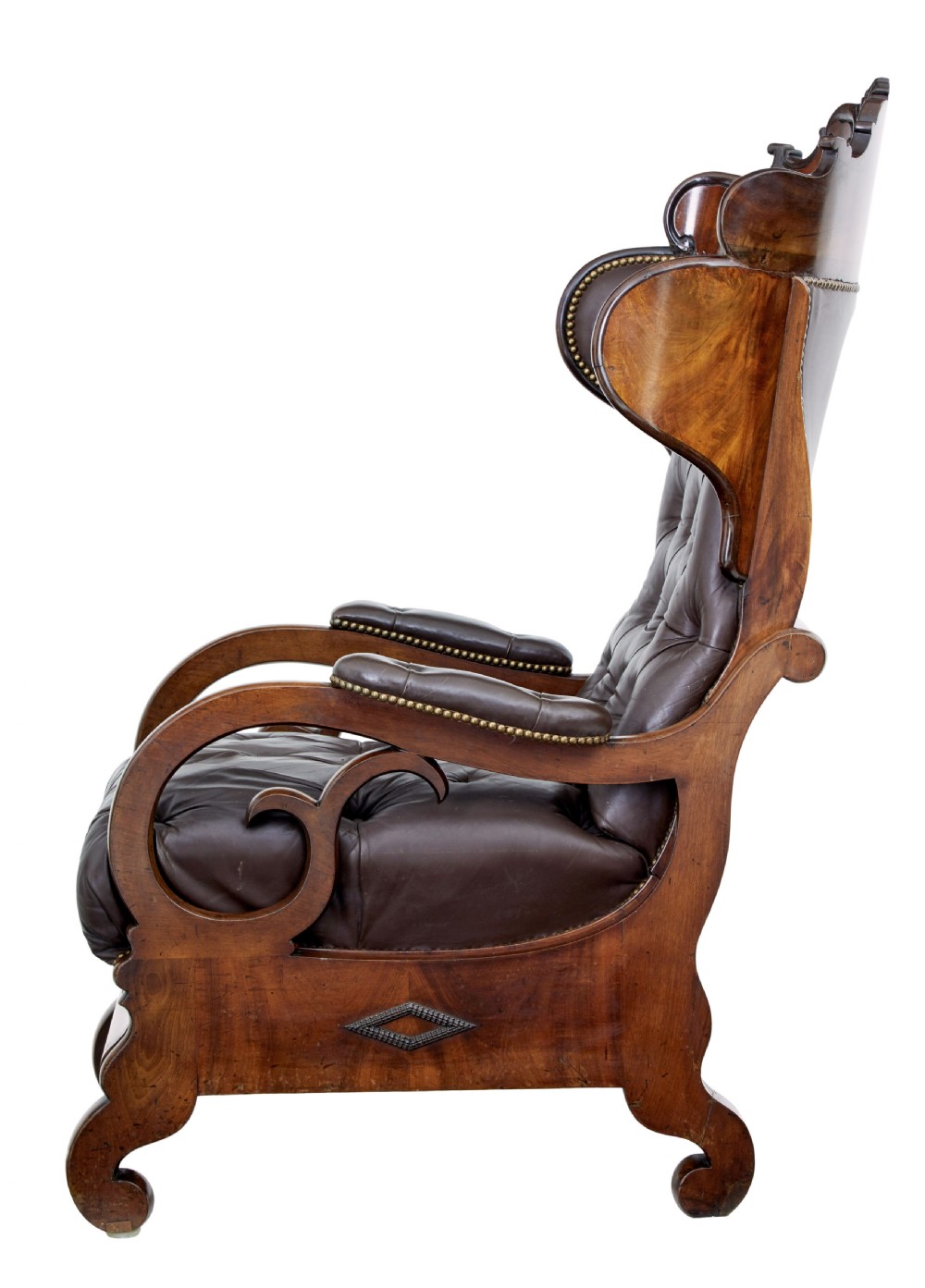 A mid-19th-century French reclining armchair featuring carved mahogany scrolled arms, a cresting motif, and deep-buttoned dark brown leather upholstery trimmed with brass studs. View II