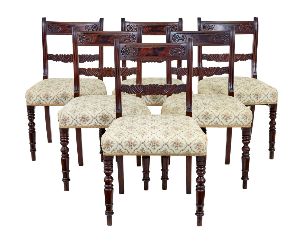 A set of six 19th-century Regency mahogany dining chairs with carved crest rails, turned front legs, and patterned upholstered seats.