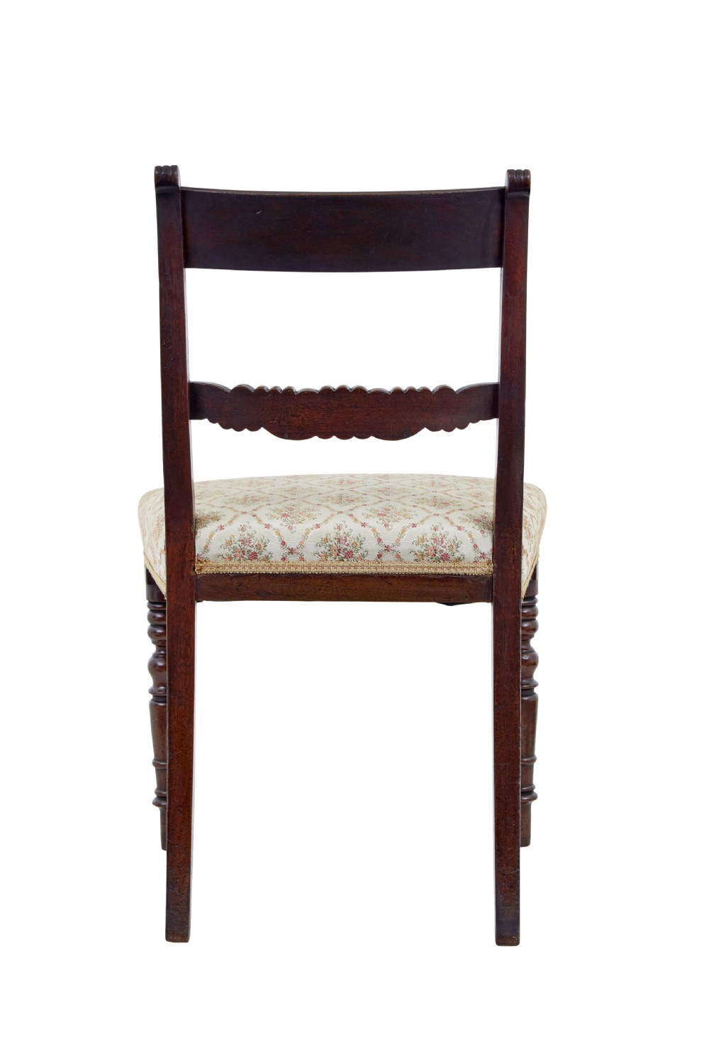 A set of six 19th-century Regency mahogany dining chairs with carved crest rails, turned front legs, and patterned upholstered seats. View V
