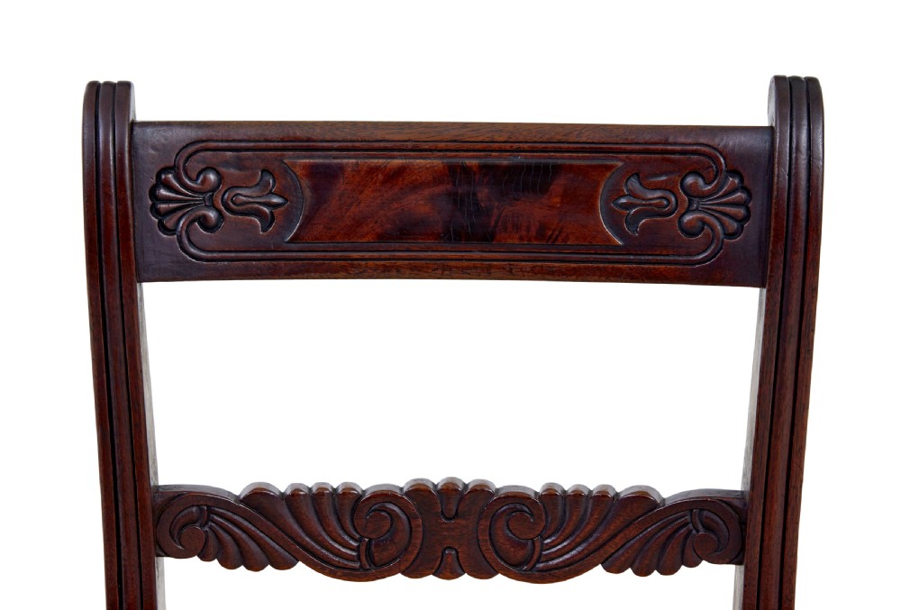 A set of six 19th-century Regency mahogany dining chairs with carved crest rails, turned front legs, and patterned upholstered seats. View VI