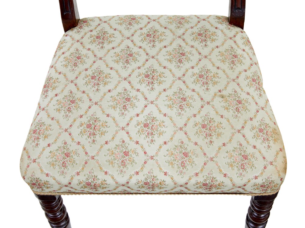 A set of six 19th-century Regency mahogany dining chairs with carved crest rails, turned front legs, and patterned upholstered seats. View VII