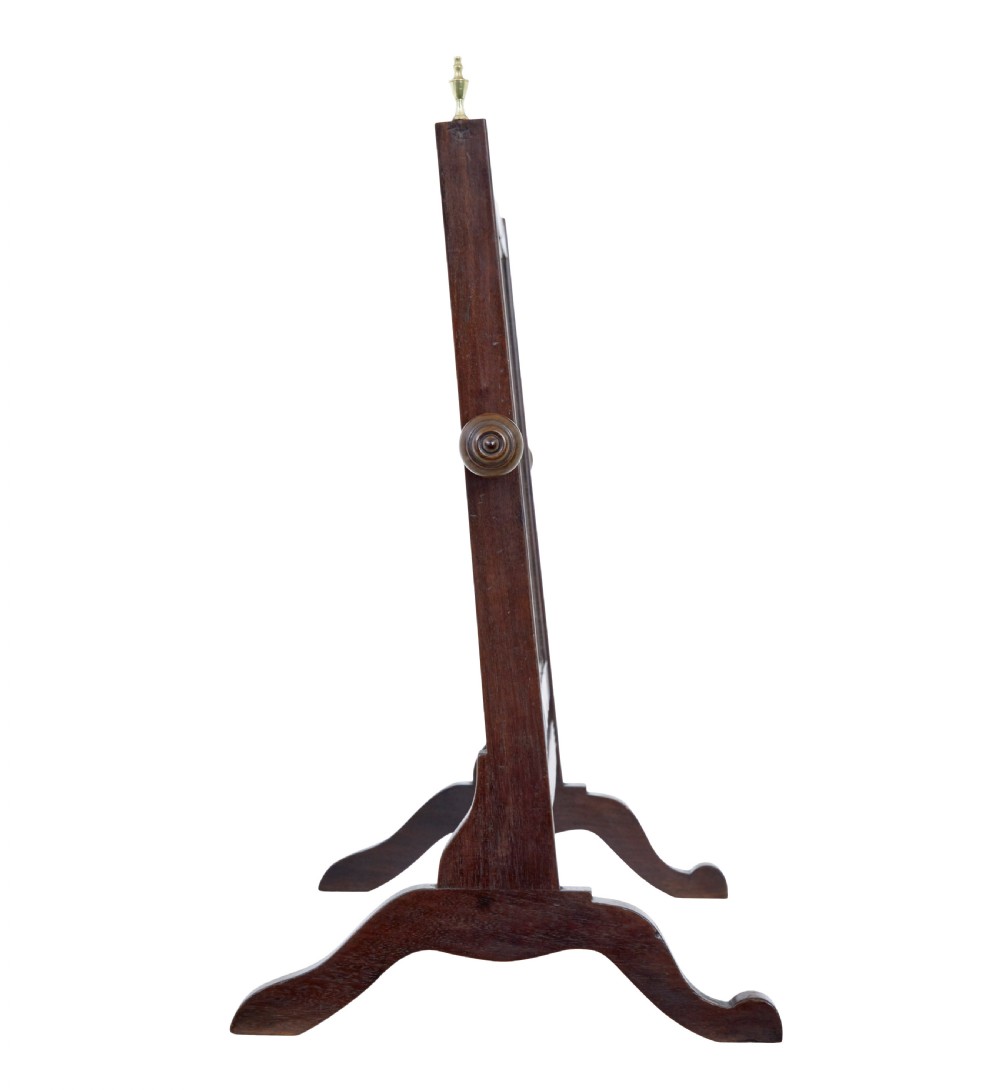 A 19th-century dark mahogany toilet mirror with a rectangular swivelling frame, reeded vertical uprights topped with brass finials, and splayed legs. View II