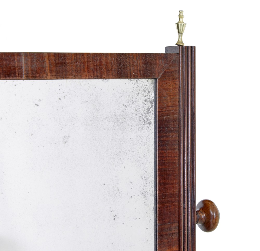 A 19th-century dark mahogany toilet mirror with a rectangular swivelling frame, reeded vertical uprights topped with brass finials, and splayed legs. View III