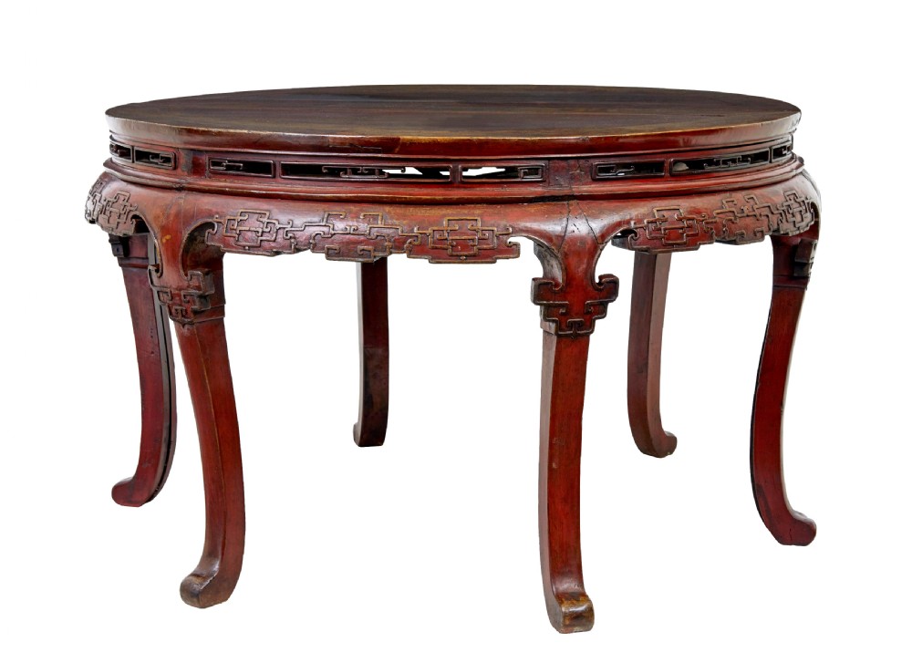 A pair of 19th-century Chinese red lacquer demi-lune tables joined together to form a circular table with carved key-fret aprons and cabriole legs.