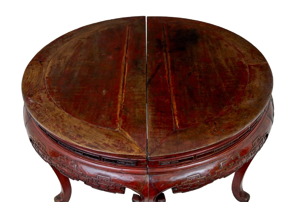 A pair of 19th-century Chinese red lacquer demi-lune tables joined together to form a circular table with carved key-fret aprons and cabriole legs. View V