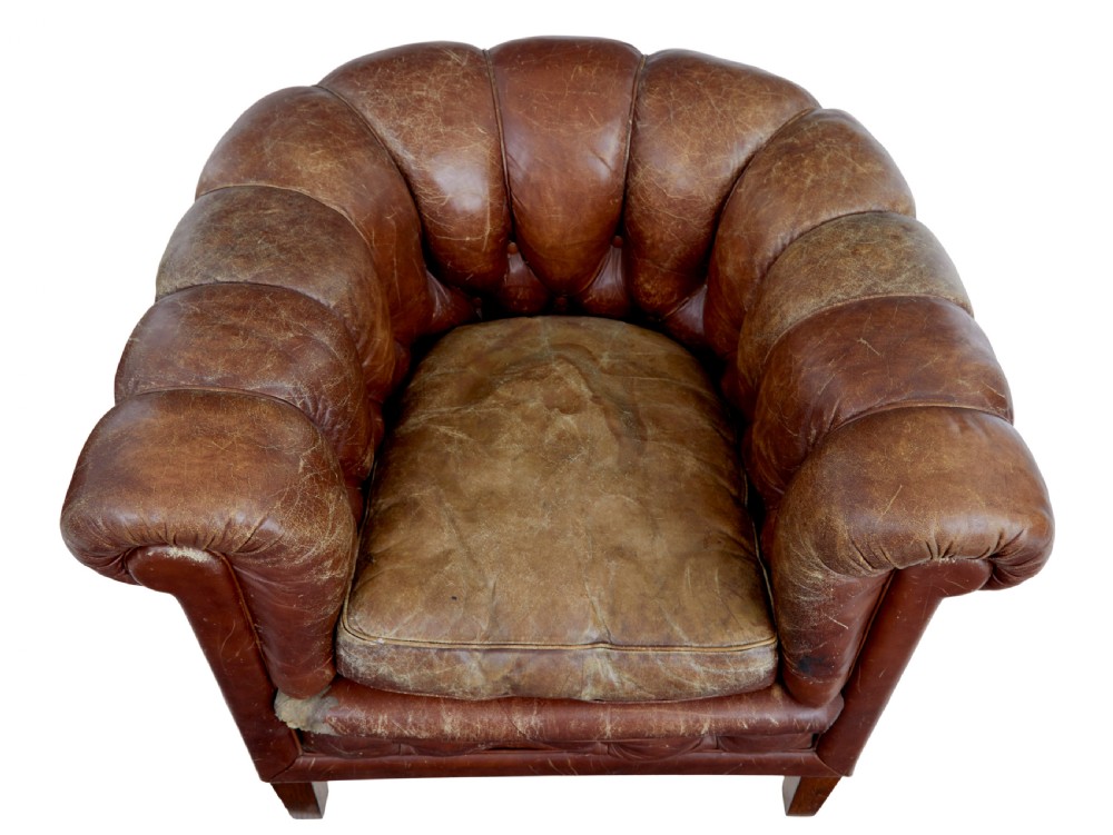 A pair of early 20th-century brown leather club armchairs with deep buttoning, rolled arms, loose seat cushions, and square timber legs. View VII