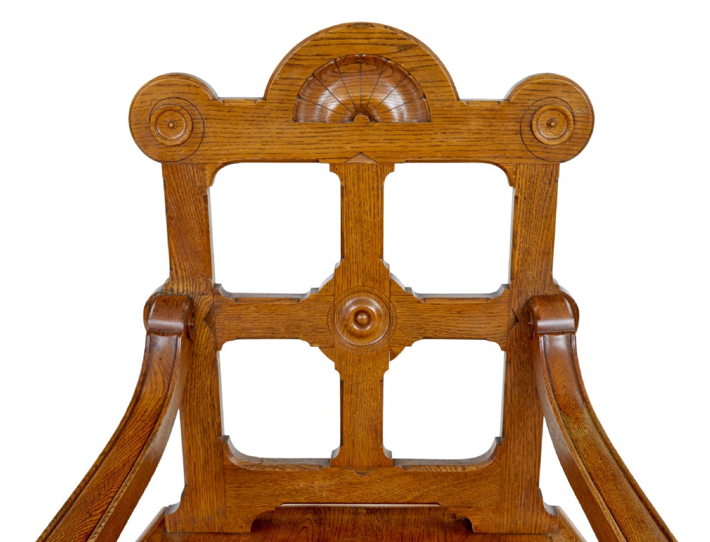 A late 19th-century carved oak armchair featuring a geometric openwork backrest with roundel details, turned legs, and sweeping wooden armrests. View III