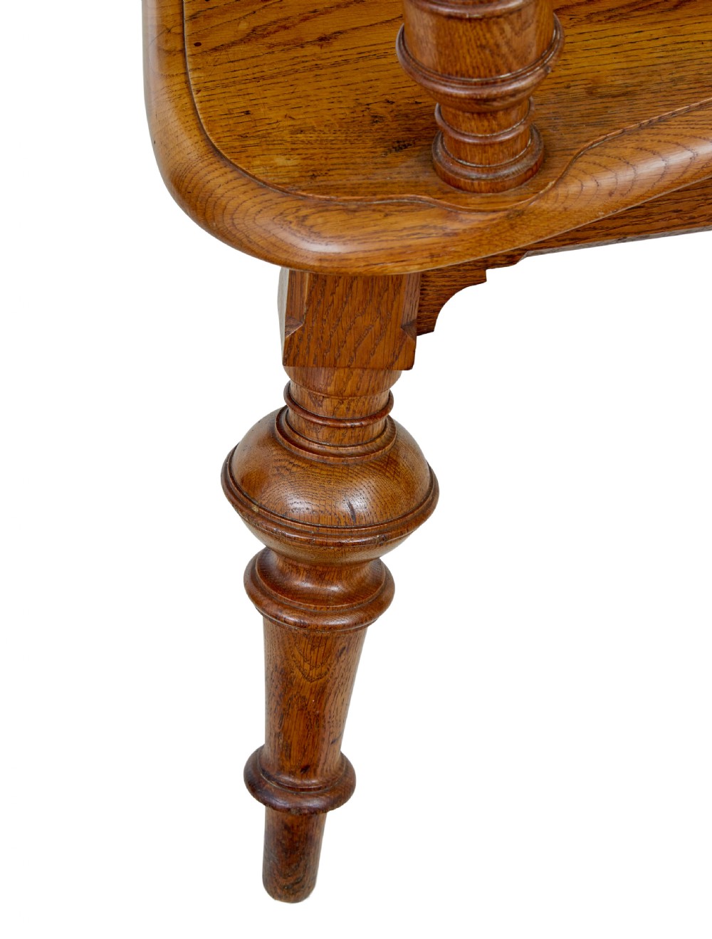 A late 19th-century carved oak armchair featuring a geometric openwork backrest with roundel details, turned legs, and sweeping wooden armrests. View V