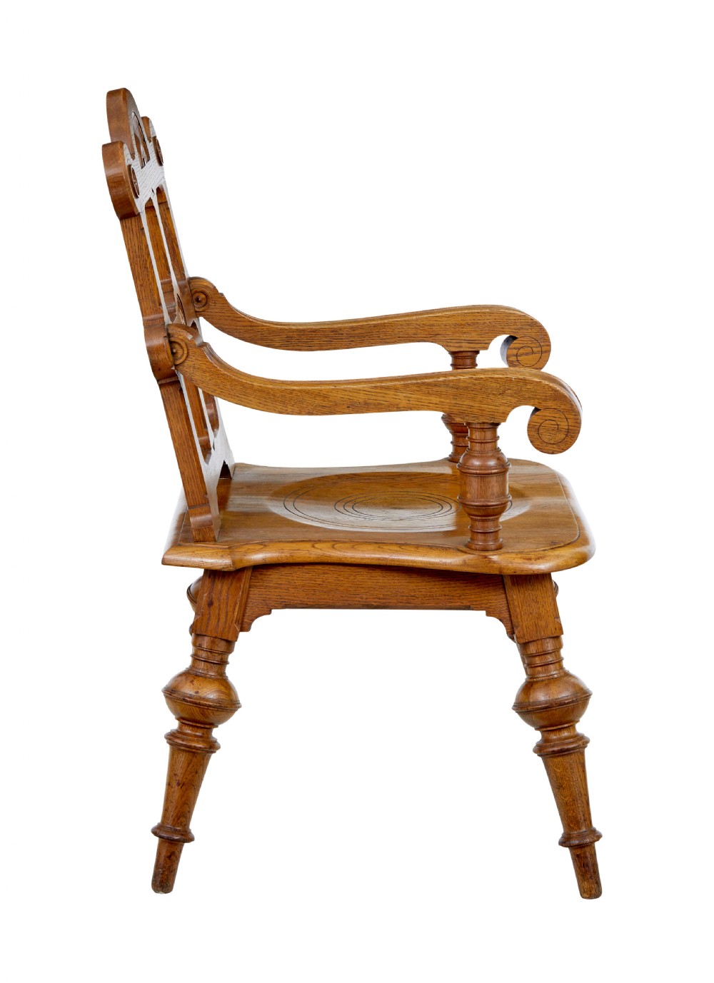 A late 19th-century carved oak armchair featuring a geometric openwork backrest with roundel details, turned legs, and sweeping wooden armrests. View VIII