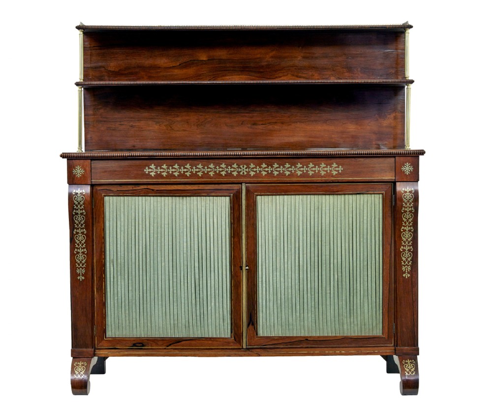 A 19th-century Regency palisander chiffonier with brass inlay, a two-tier raised shelf back supported by brass columns, and green pleated fabric door panels. View III