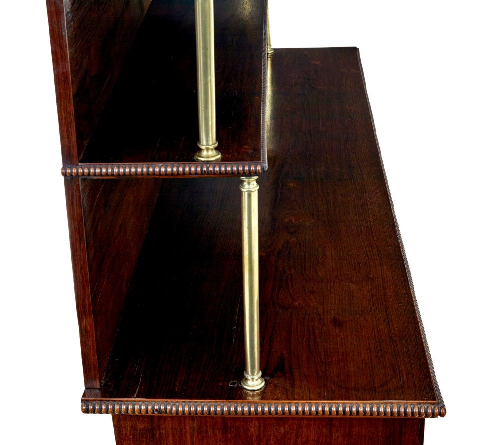 A 19th-century Regency palisander chiffonier with brass inlay, a two-tier raised shelf back supported by brass columns, and green pleated fabric door panels. View VII