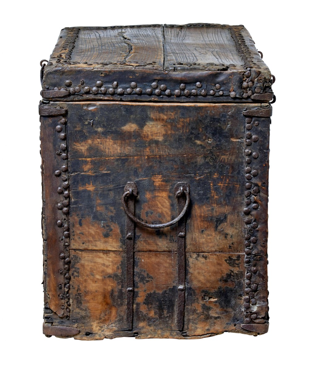 A dark brown 18th-century Chinese hardwood coffer chest with iron studding, metal corner bindings, a central latch, and side drop-handles. View V