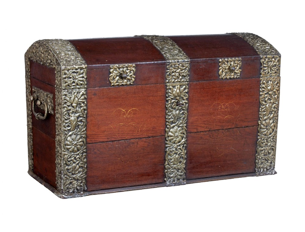 An 18th-century Danish dark oak dome-top coffer featuring intricate embossed brass straps, dual lock plates, and heavy side carrying handles.