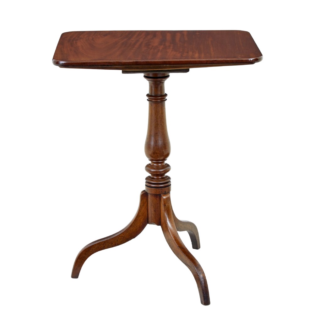 An early 19th-century mahogany tilt-top occasional table featuring a rectangular top, turned baluster stem, and three splayed legs.