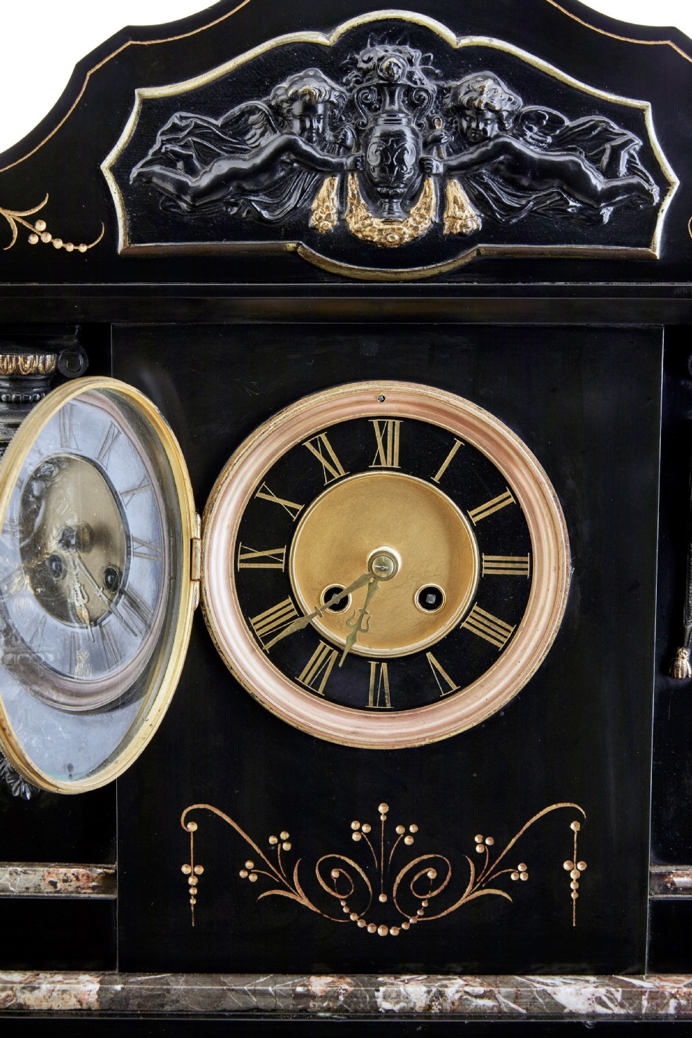 A High Victorian black marble mantel clock featuring gold incised scrollwork, a classical cherub relief panel, and a central circular dial with Roman numerals. View VIII