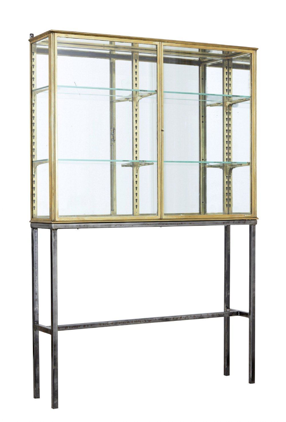 A 1920s French brass glazed display cabinet by Siegel resting on a tall dark steel base with adjustable internal glass shelves.