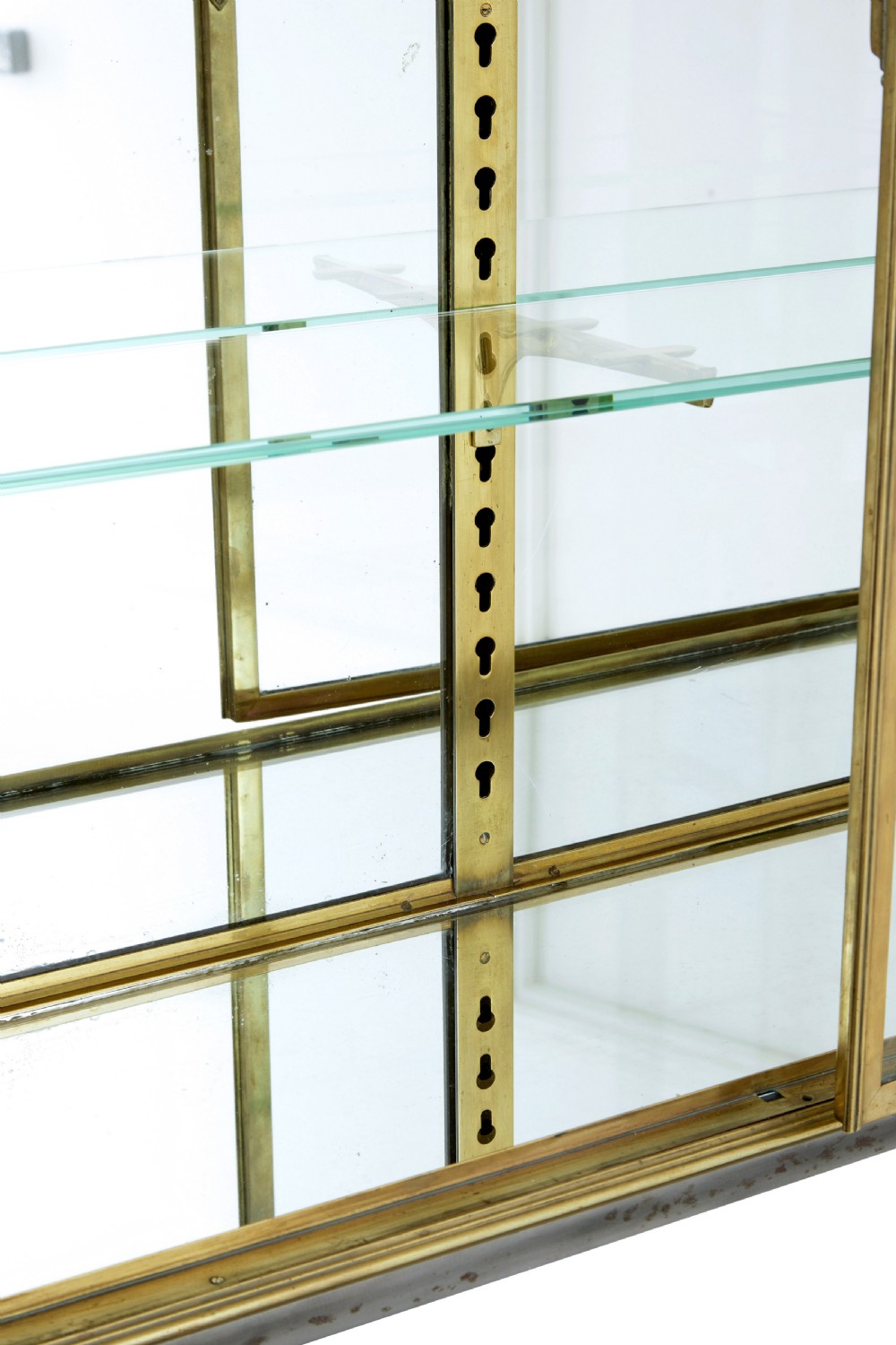A 1920s French brass glazed display cabinet by Siegel resting on a tall dark steel base with adjustable internal glass shelves. View IV