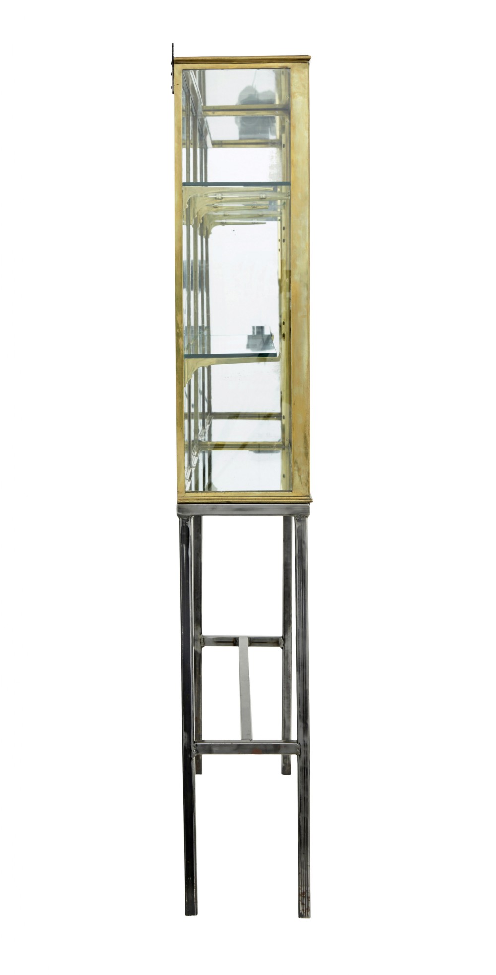 A 1920s French brass glazed display cabinet by Siegel resting on a tall dark steel base with adjustable internal glass shelves. View V