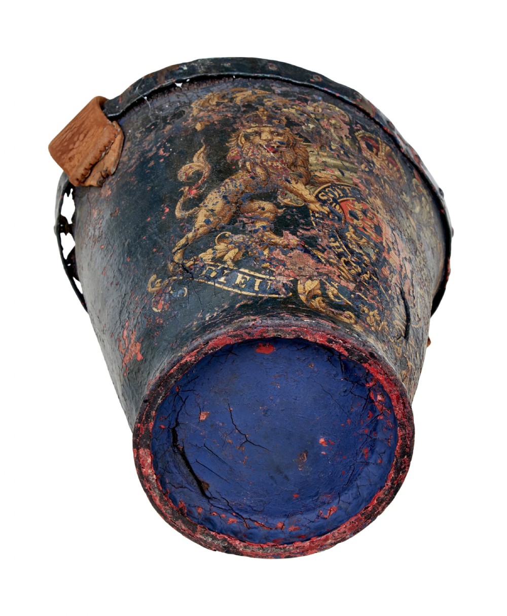 A late eighteenth-century leather fire bucket decorated with a hand-painted royal coat of arms, copper studding around the rim and base, and a thick leather handle. View VI