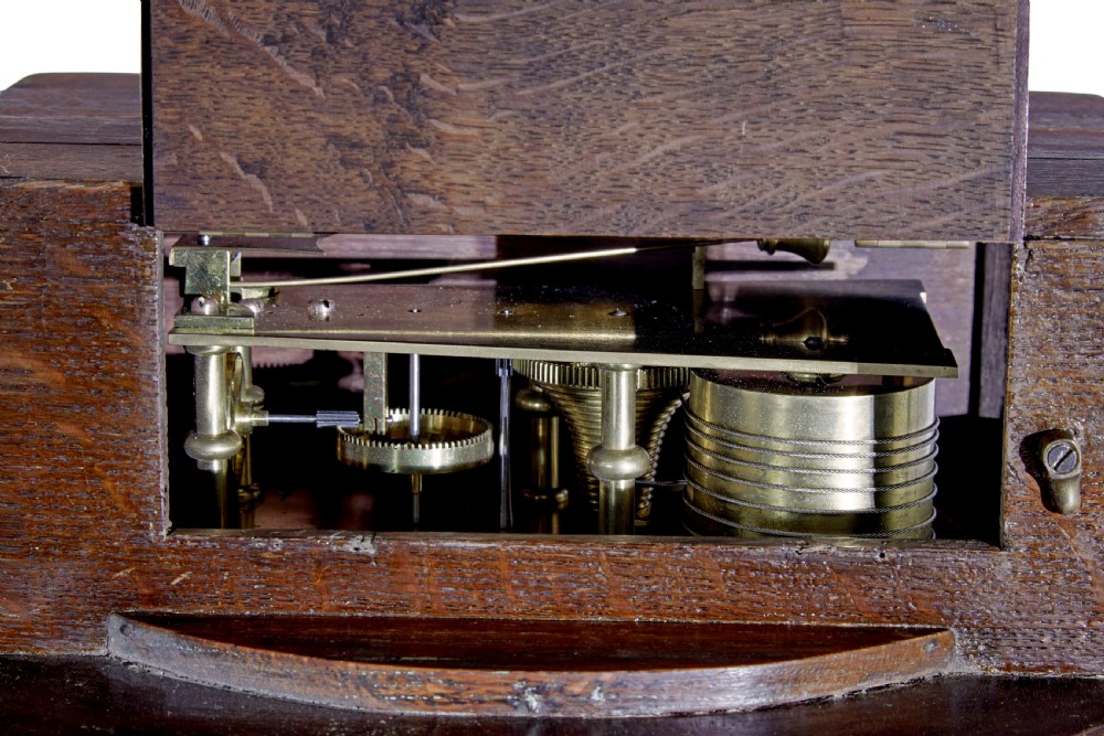 An 18th-century Georgian wall clock featuring an engraved silvered dial with Roman numerals, a brass bezel, and a circular mahogany surround. View VII