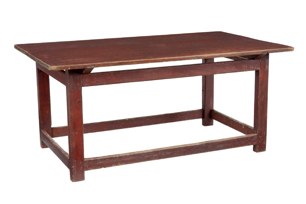 A large 19th-century Scandinavian pine table with a red-painted finish, rectangular plank top, and lower box stretcher.