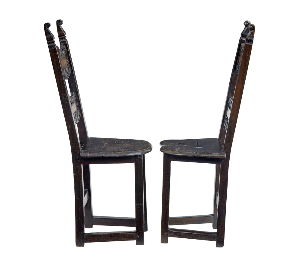 A pair of 19th-century dark oak Carolean-inspired hall chairs featuring intricate scrollwork carving, inlaid back panels, and turned finials. View III