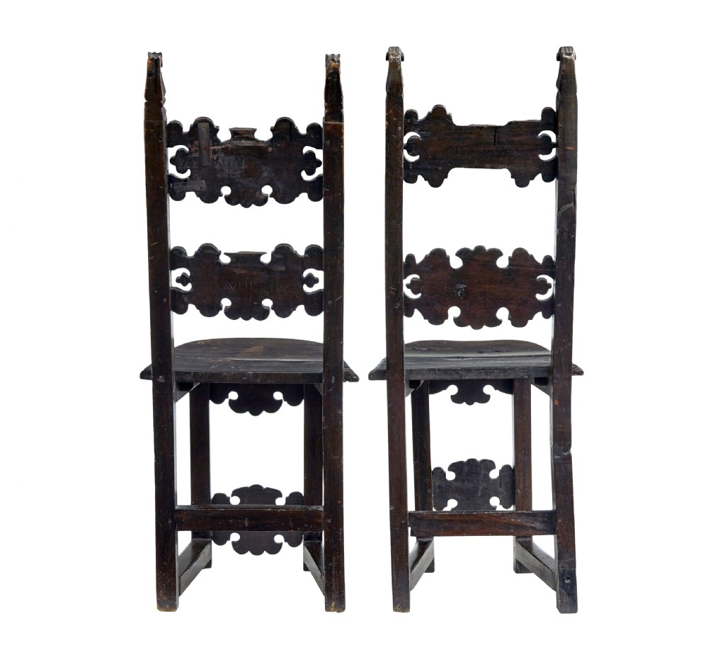A pair of 19th-century dark oak Carolean-inspired hall chairs featuring intricate scrollwork carving, inlaid back panels, and turned finials. View IV