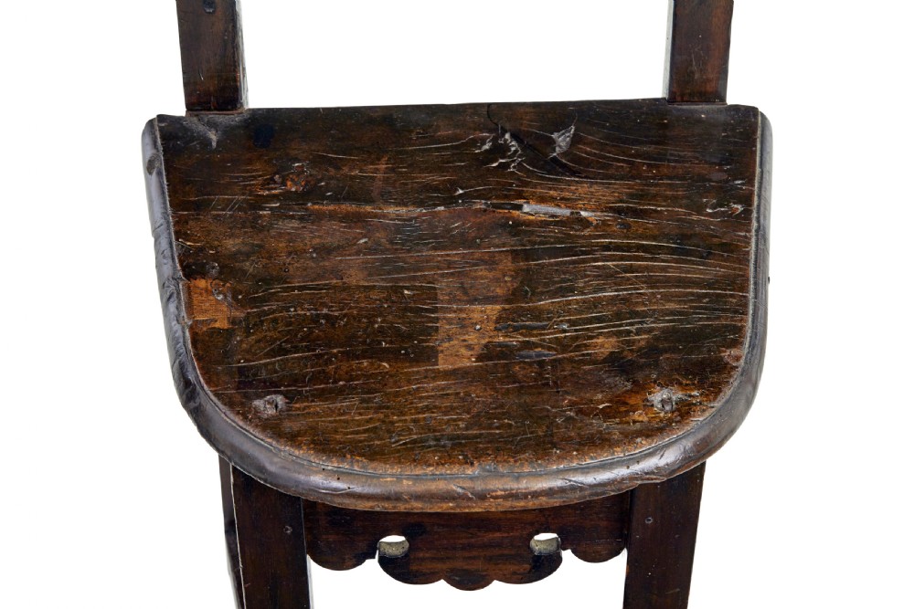 A pair of 19th-century dark oak Carolean-inspired hall chairs featuring intricate scrollwork carving, inlaid back panels, and turned finials. View V