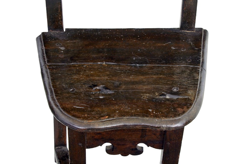 A pair of 19th-century dark oak Carolean-inspired hall chairs featuring intricate scrollwork carving, inlaid back panels, and turned finials. View VI