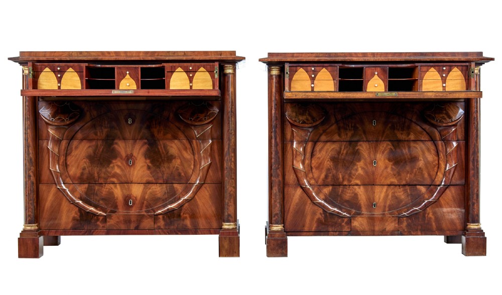 A matching pair of early nineteenth-century mahogany Biedermeier commodes featuring carved cornucopia motifs and side columns. View II