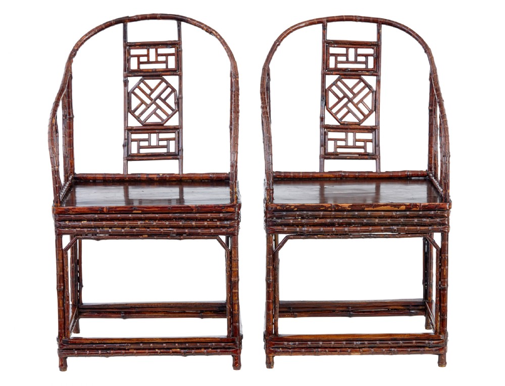 A pair of 19th-century dark brown bamboo armchairs featuring rounded crest rails, geometric lattice splats, and woven panel seats.