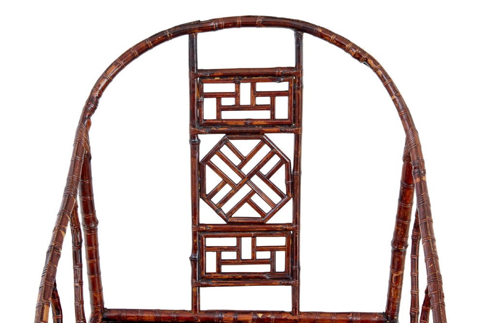 A pair of 19th-century dark brown bamboo armchairs featuring rounded crest rails, geometric lattice splats, and woven panel seats. View IV