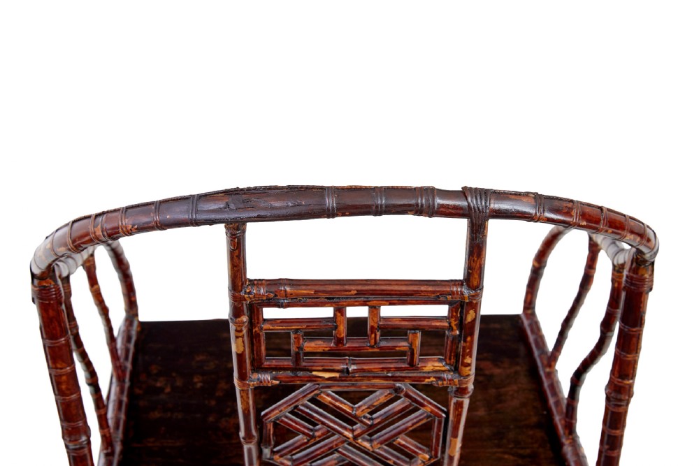 A pair of 19th-century dark brown bamboo armchairs featuring rounded crest rails, geometric lattice splats, and woven panel seats. View V