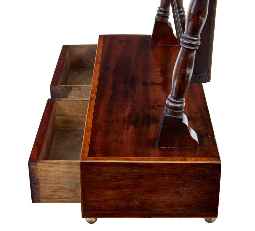 An antique Victorian mahogany toilet mirror with a rectangular tilting glass plate supported by turned upright pillars above a two-drawer inlaid base. View VI