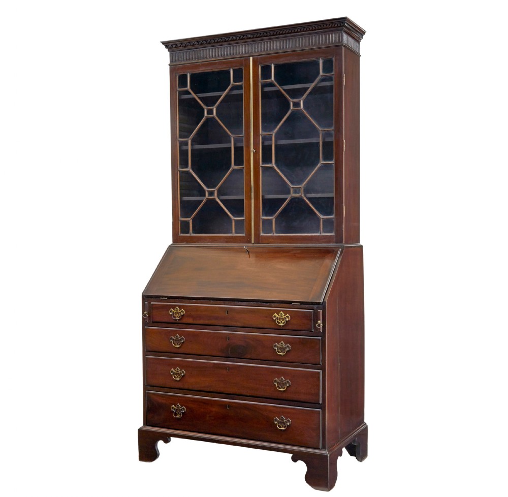 An early nineteenth-century mahogany bureau bookcase featuring upper astragal glazed doors, a slant fall-front writing section, and four graduated lower drawers.