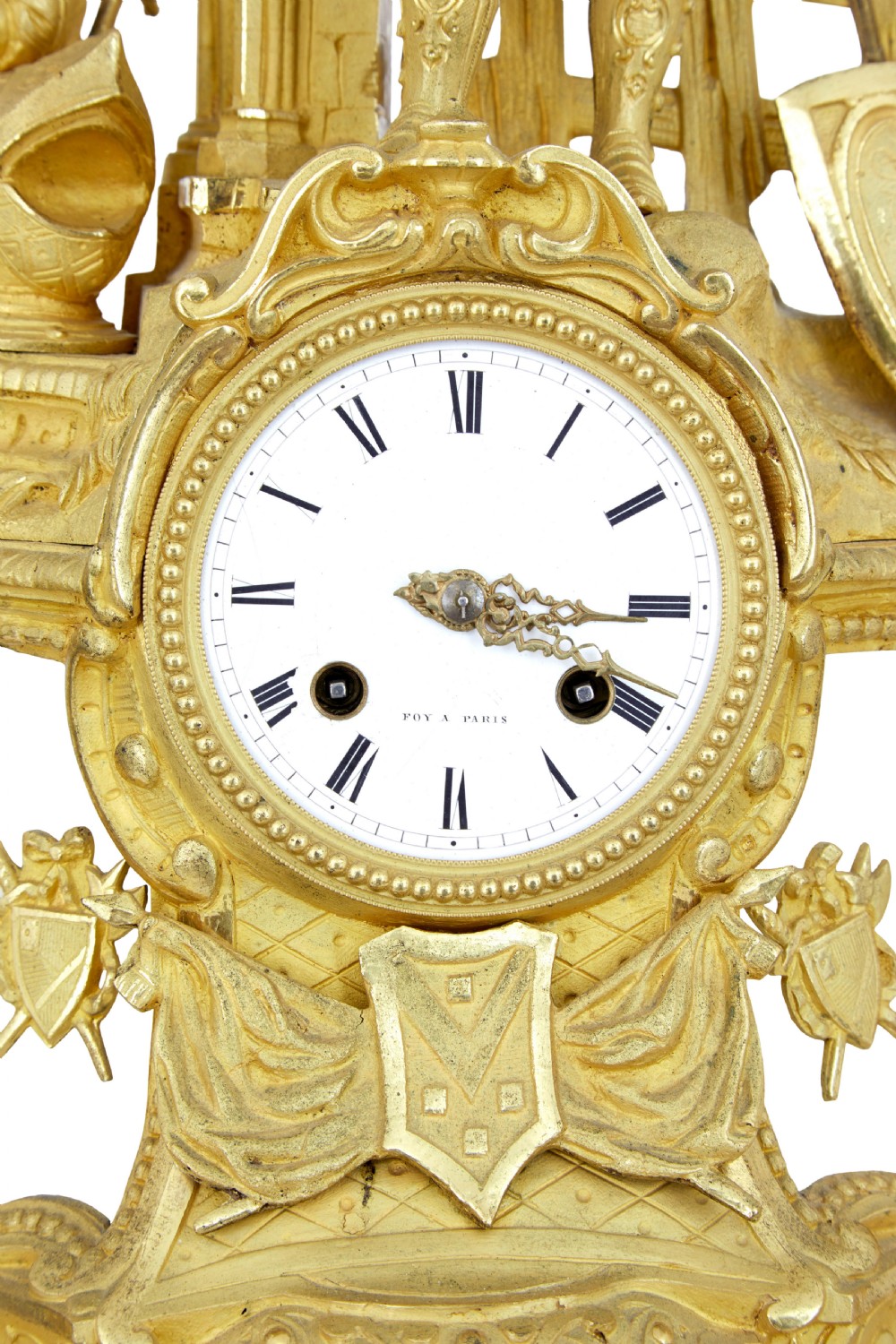 A 19th-century French gilt bronze ormolu mantel clock featuring a knight figure holding a shield and flag above a white enamel Roman numeral dial set into a scrolled base. View VII
