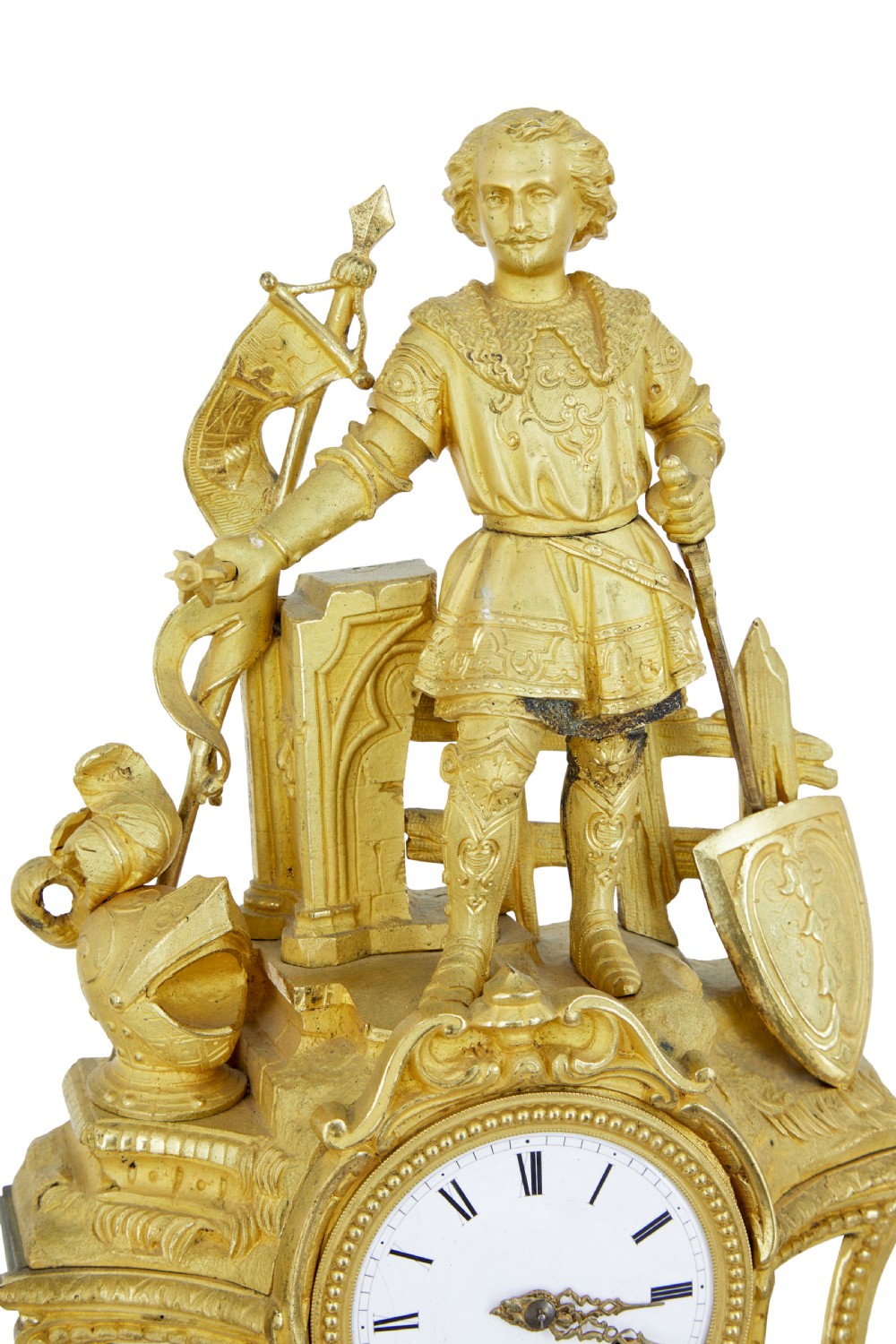A 19th-century French gilt bronze ormolu mantel clock featuring a knight figure holding a shield and flag above a white enamel Roman numeral dial set into a scrolled base. View IX