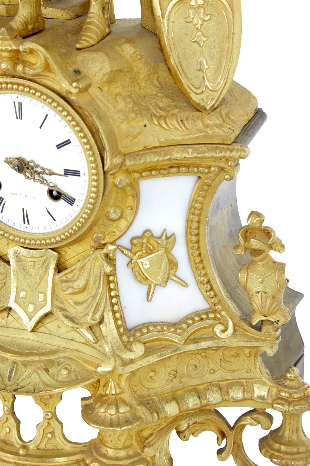 A 19th-century French gilt bronze ormolu mantel clock featuring a knight figure holding a shield and flag above a white enamel Roman numeral dial set into a scrolled base. View X