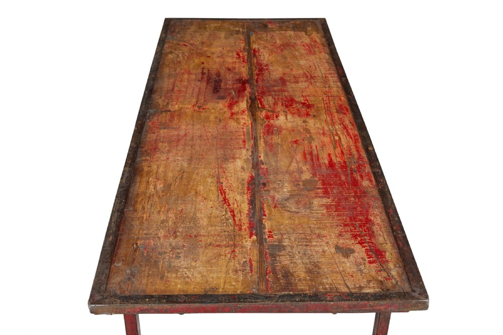A rectangular folding table featuring a weathered wood top set within a distressed red-painted metal frame and leg structure. View VII