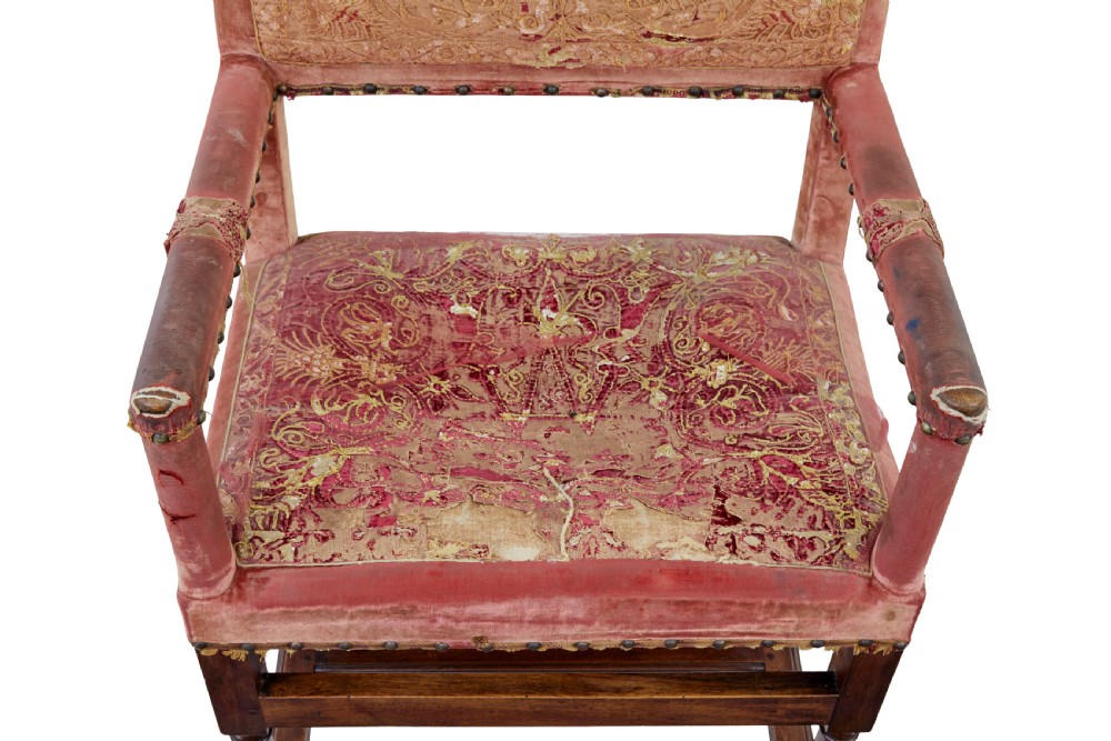 A set of 19th-century carved walnut armchairs with worn red velvet upholstery and embroidered decorative backrest panels. View V