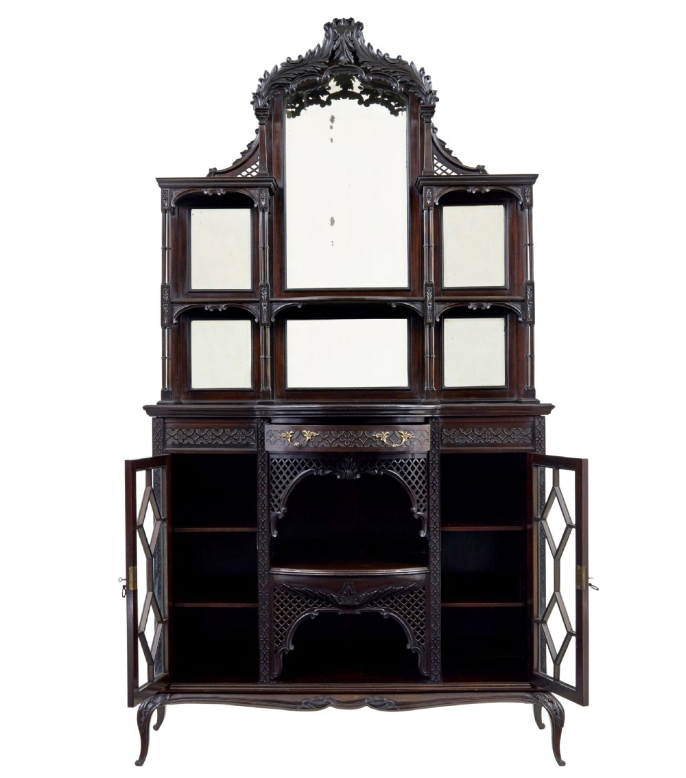 An Edwardian Chippendale Revival dark mahogany display cabinet featuring a multi-paneled mirrored upper section, carved crest, fretwork, and glazed side doors on cabriole legs. View II
