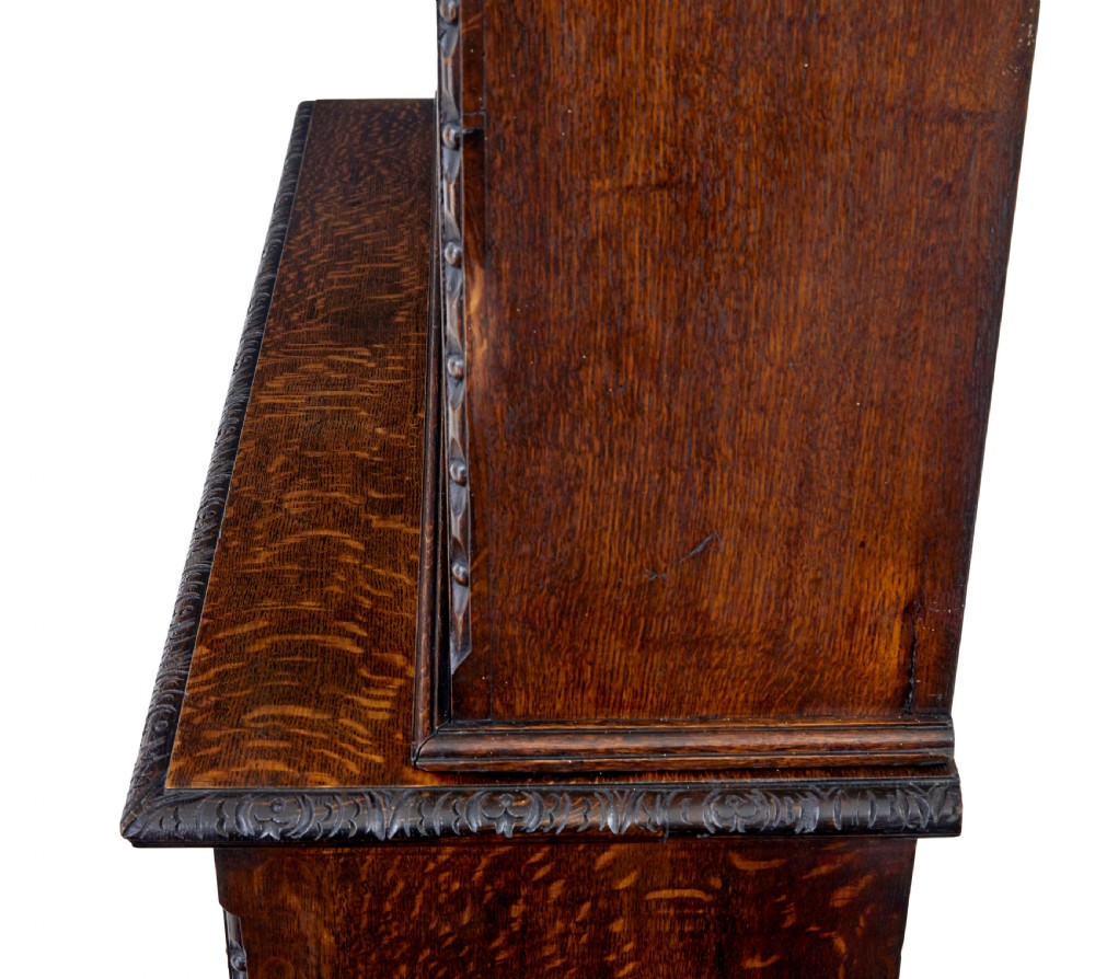 A 19th-century dark oak architectural cabinet featuring an open upper shelf section with a broken pediment crown and lower cupboard doors adorned with floral marquetry inlay. View VIII