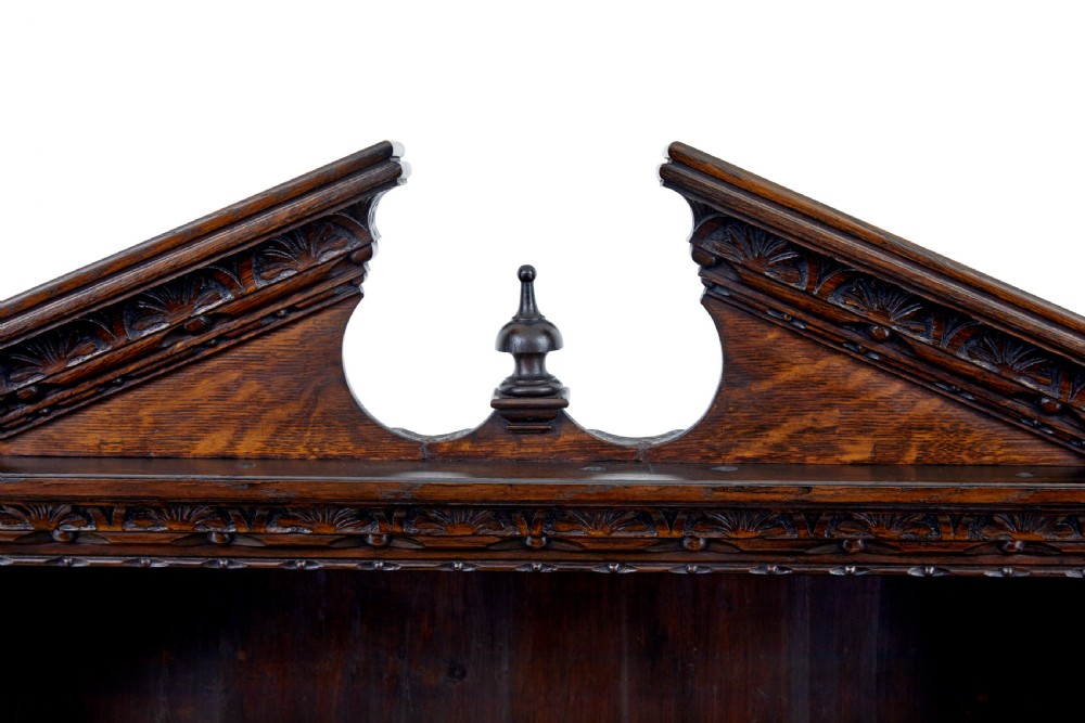 A 19th-century dark oak architectural cabinet featuring an open upper shelf section with a broken pediment crown and lower cupboard doors adorned with floral marquetry inlay. View IX