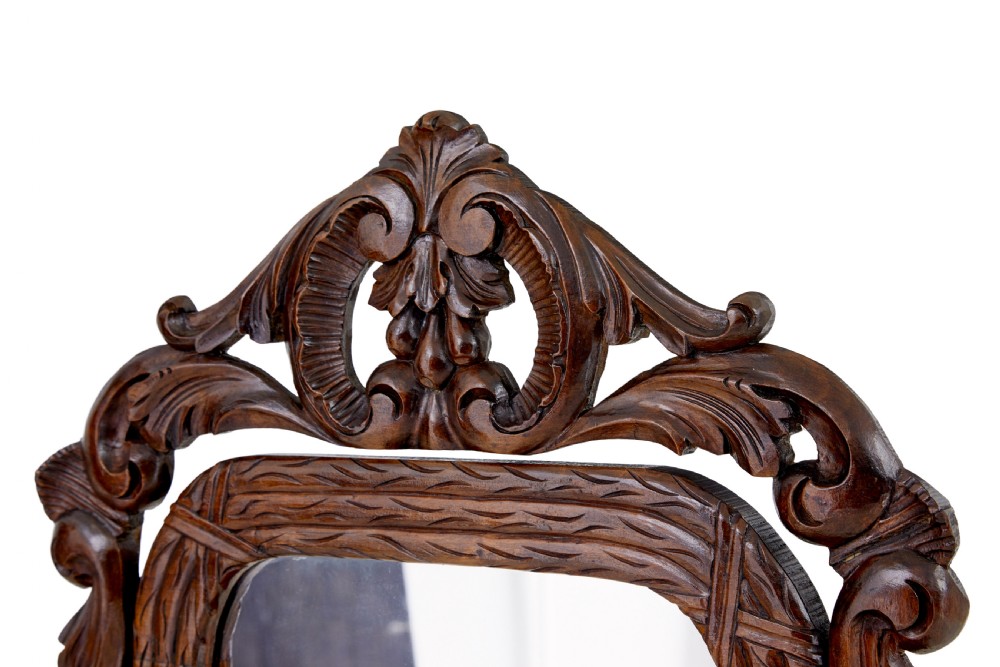 A late 19th-century dark oak tabletop vanity mirror featuring elaborate Rococo Revival scrollwork and an arched frame. View V