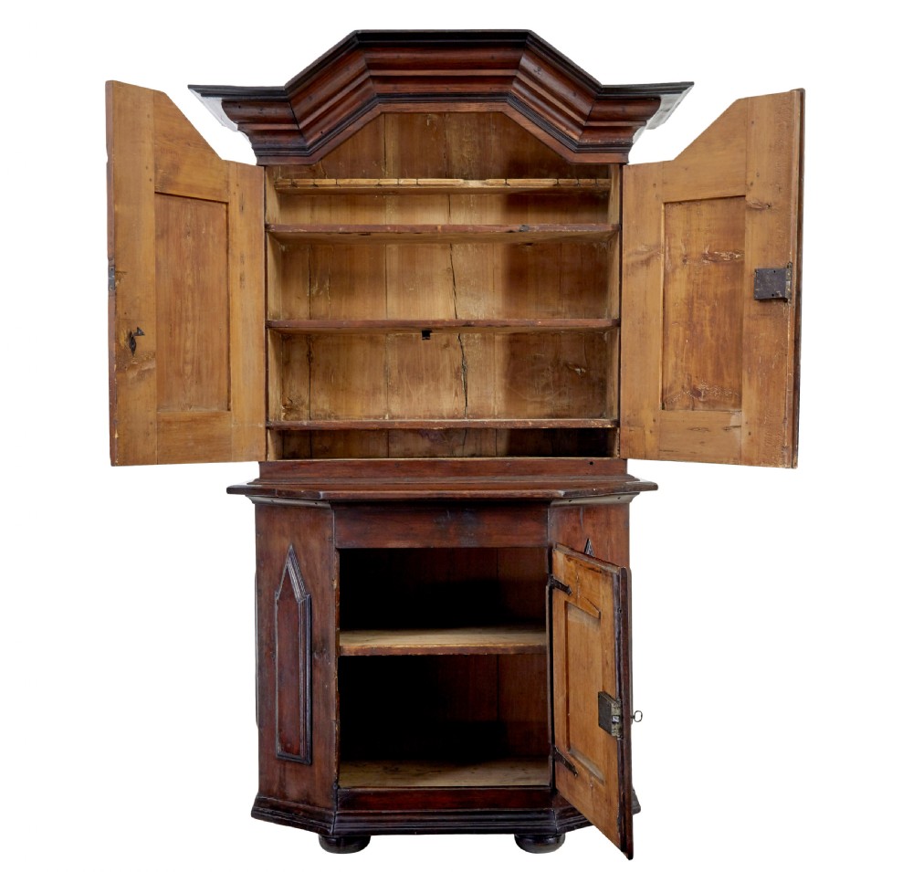 An 18th-century Scandinavian pine Baroque cupboard featuring faceted sides, geometric diamond mouldings on the upper doors, and a projected corniced top. View II