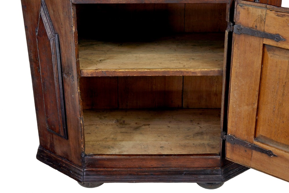An 18th-century Scandinavian pine Baroque cupboard featuring faceted sides, geometric diamond mouldings on the upper doors, and a projected corniced top. View VI