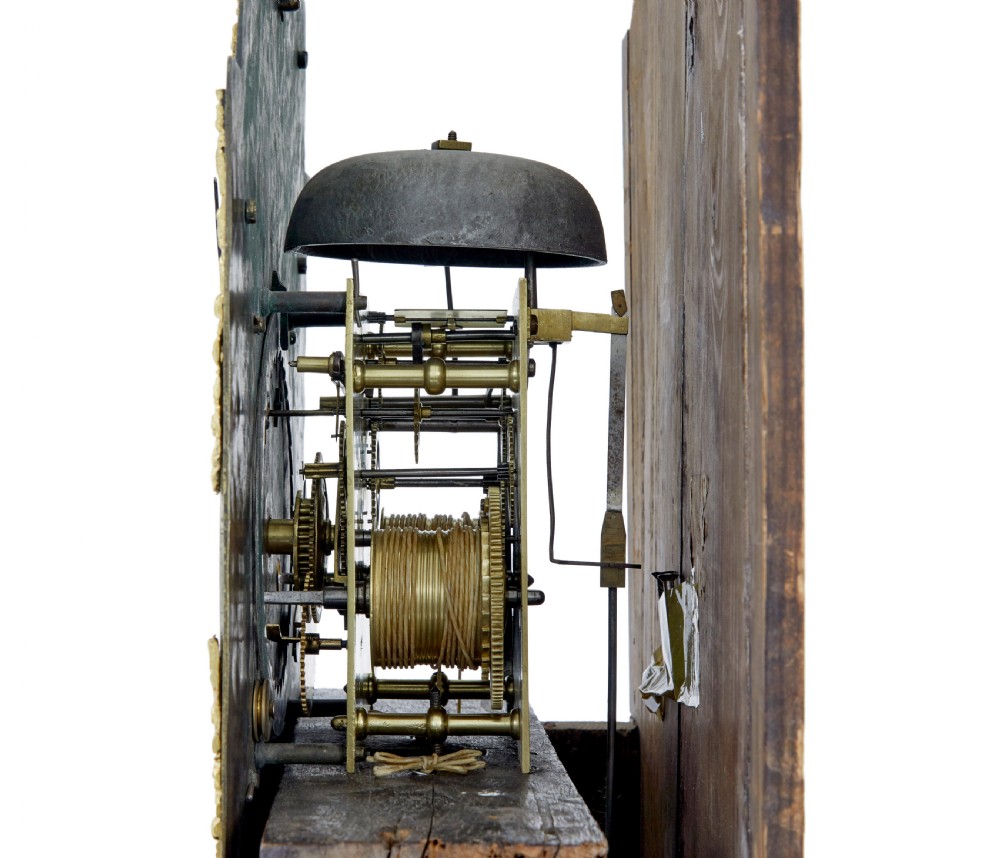 An 18th-century oak longcase clock featuring a brass dial, pediment hood with brass finials, rectangular trunk door, and plinth base. View IX