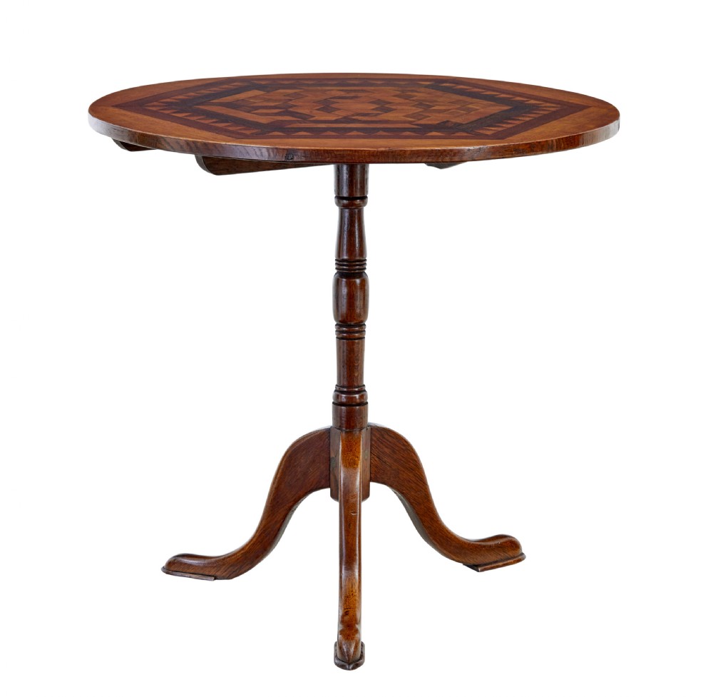 A 19th-century round oak occasional table featuring a geometric inlaid wood top, a turned central pedestal, and three splayed legs.