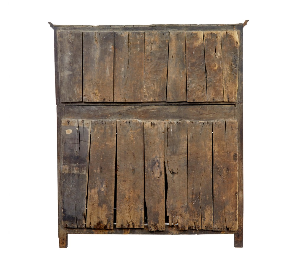 A seventeenth-century dark oak Welsh court cupboard featuring raised geometric panels, turned pendant drops, small central drawers, and double lower doors. View VII